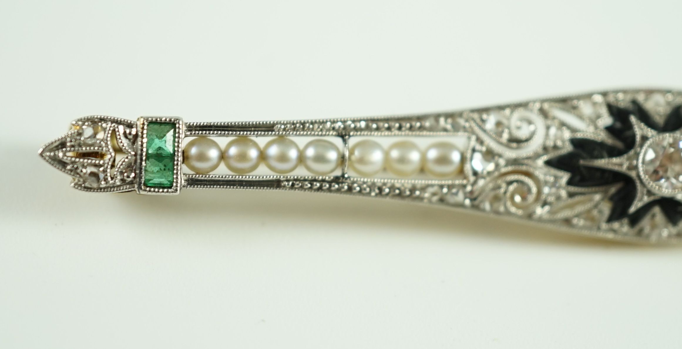 A 1920's gold and platinum, emerald, seed pearl, diamond and black onyx set bar brooch